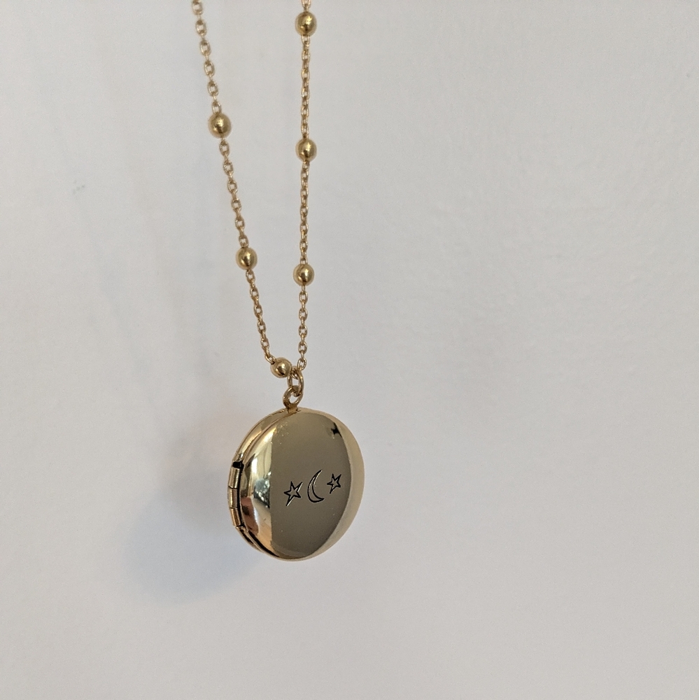 Gold coloured locket with moon and stars design